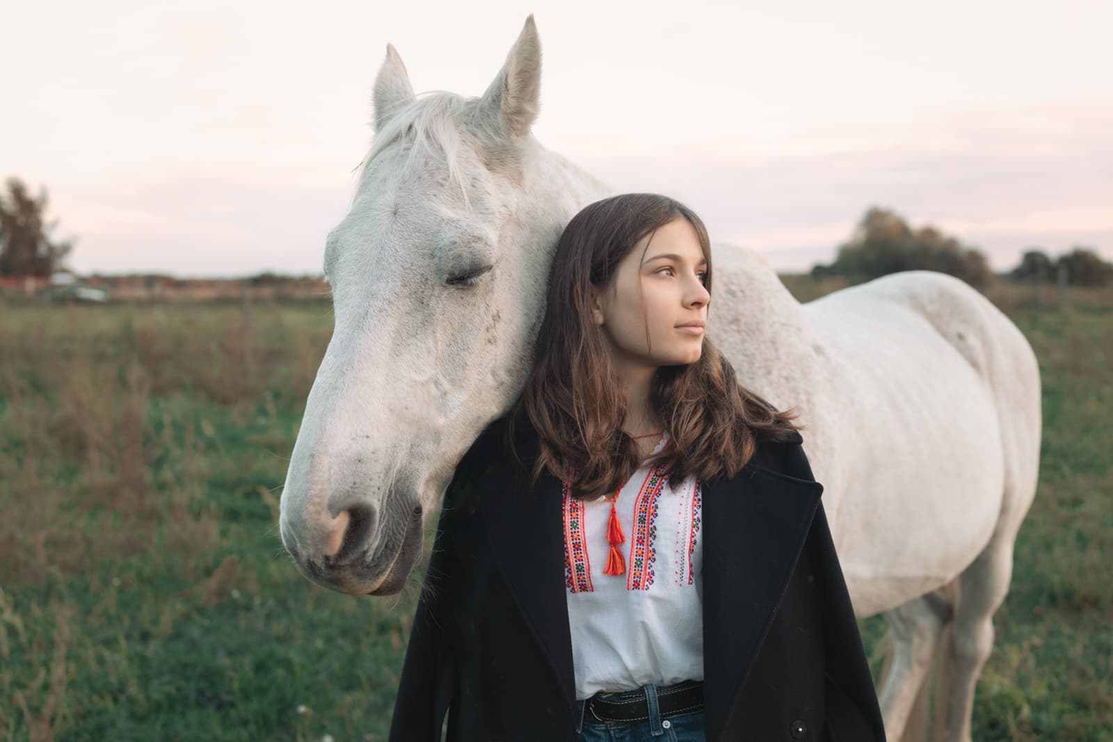 Woman with white horse in field
