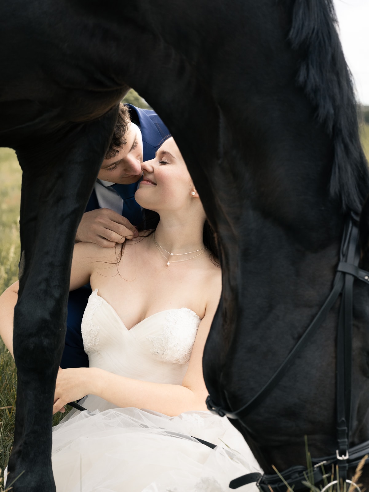 Wedding couple in creative pose under horse's belly