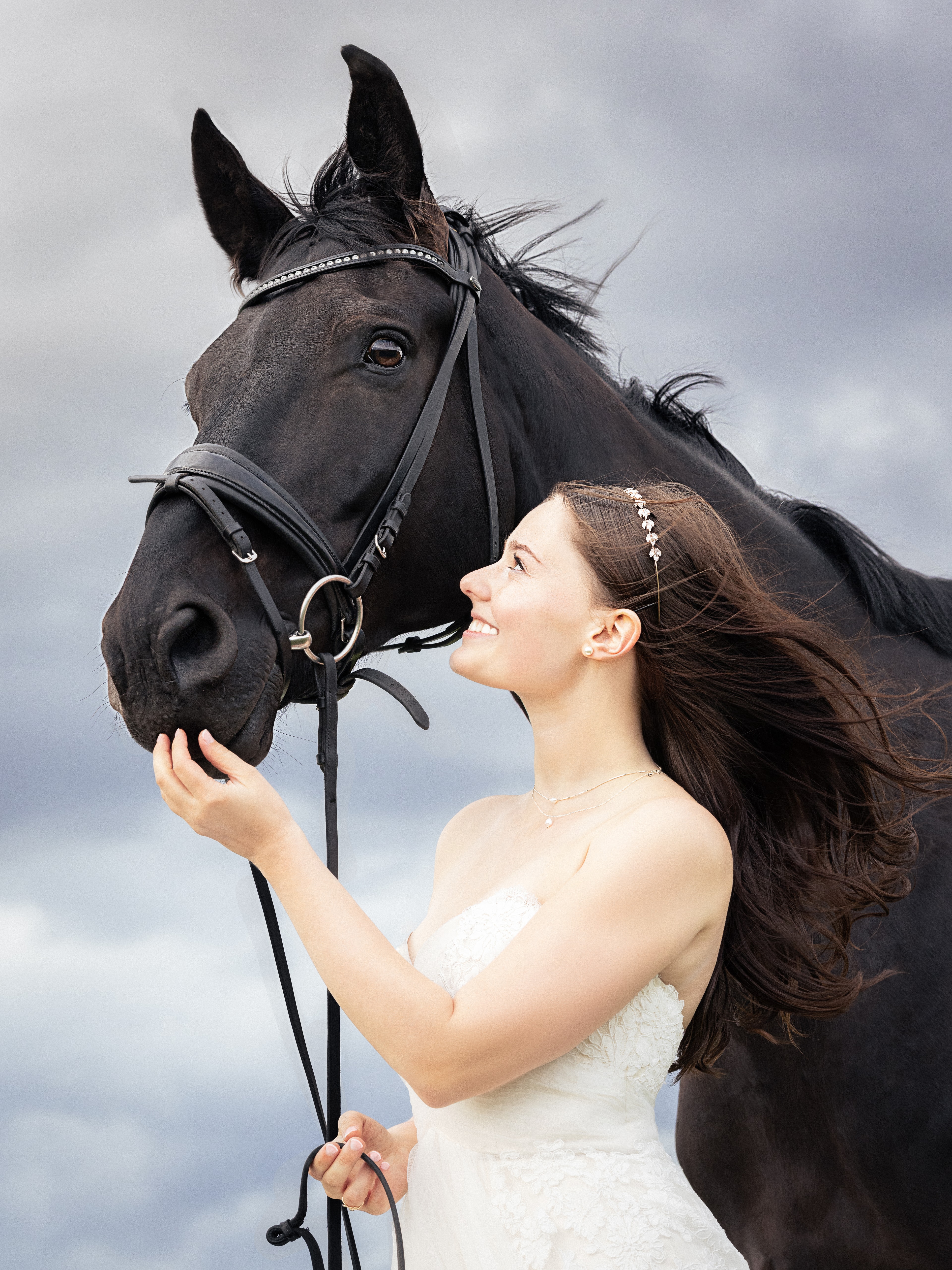 Bride in white wedding dress with dark horse