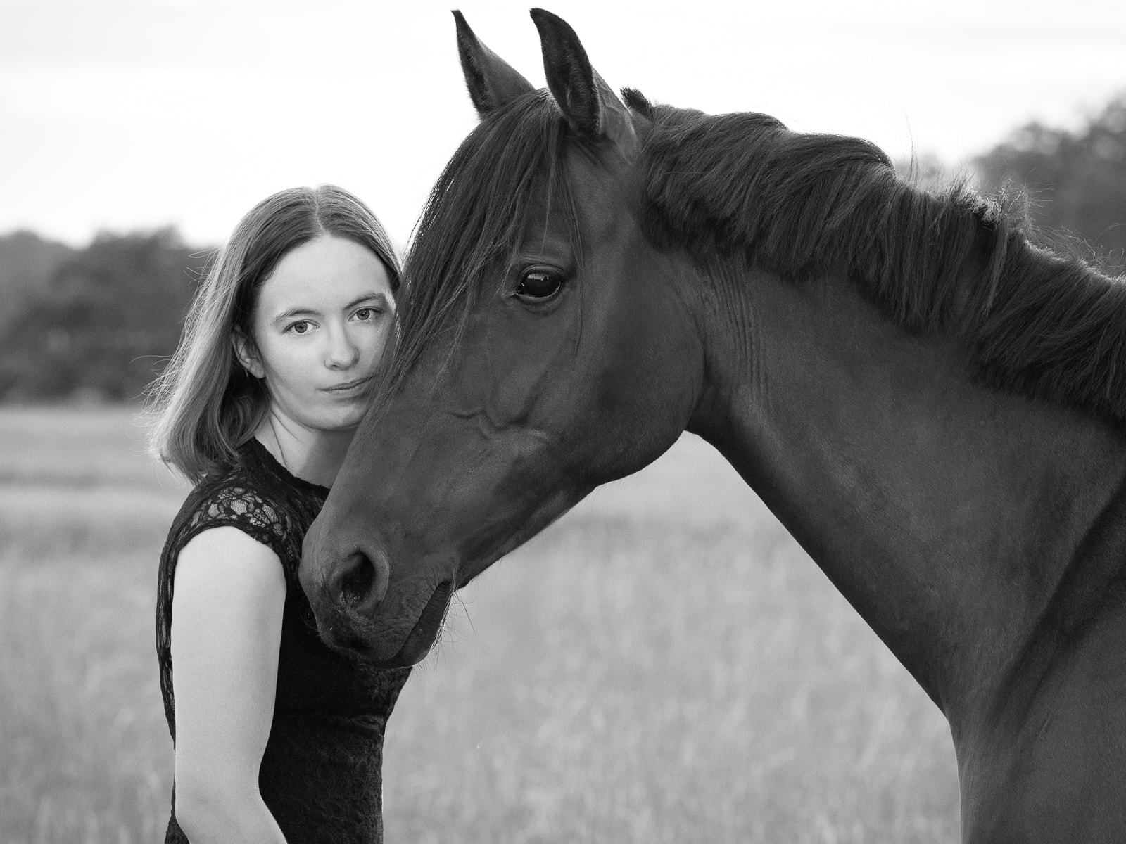 Intimate moment between woman and horse in artistic black and white
